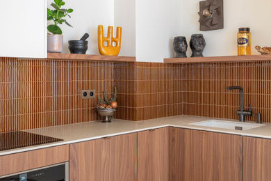 Cette image montre une cuisine design en bois brun avec un plan de travail blanc.