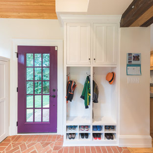 Новые идеи обустройства дома: тамбур в классическом стиле с белыми стенами, кирпичным полом, одностворчатой входной дверью, фиолетовой входной дверью и красным полом