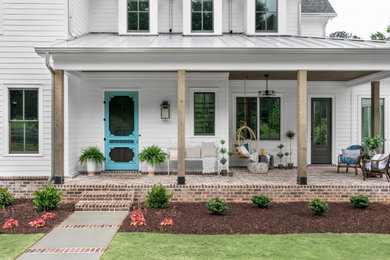 Large country two-storey white house exterior in Atlanta with concrete fiberboard siding, a gable roof, a mixed roof, a black roof and board and batten siding.