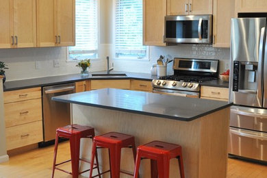Example of a mid-sized trendy l-shaped light wood floor eat-in kitchen design in Burlington with an undermount sink, shaker cabinets, light wood cabinets, quartz countertops, white backsplash, subway tile backsplash, stainless steel appliances and an island