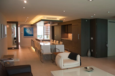 This is an example of a medium sized contemporary galley open plan kitchen in Miami with a submerged sink, flat-panel cabinets, dark wood cabinets, granite worktops, beige splashback, stone slab splashback, integrated appliances, porcelain flooring, an island, beige floors and grey worktops.
