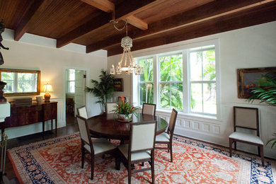Inspiration for a large tropical dark wood floor dining room remodel in Miami with white walls, a standard fireplace and a plaster fireplace