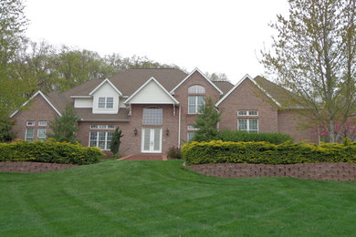 Large red two-story brick exterior home idea in Chicago