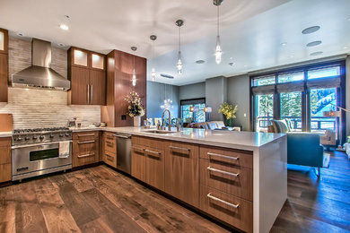 Trendy medium tone wood floor and brown floor open concept kitchen photo in Sacramento with an undermount sink, flat-panel cabinets, dark wood cabinets, quartz countertops, beige backsplash, stone tile backsplash, stainless steel appliances and a peninsula