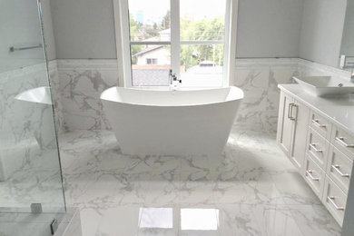 Mid-sized mid-century modern master black and white tile, gray tile and marble tile marble floor and white floor bathroom photo in Calgary with raised-panel cabinets, white cabinets, a one-piece toilet, white walls, a vessel sink and solid surface countertops