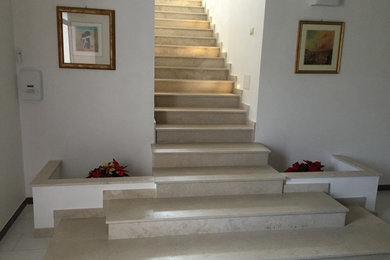 Modelo de escalera recta contemporánea grande con escalones de piedra caliza, contrahuellas de piedra caliza y barandilla de varios materiales
