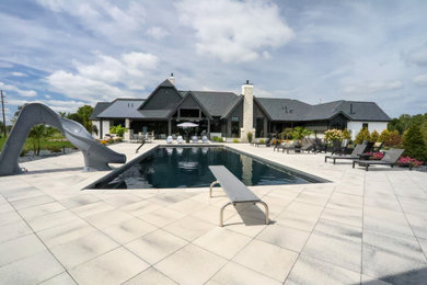 Inspiration for a huge transitional backyard concrete paver and rectangular pool house remodel in Other