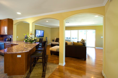 Family room - mid-sized traditional enclosed medium tone wood floor and brown floor family room idea in Los Angeles with beige walls, no fireplace and a wall-mounted tv