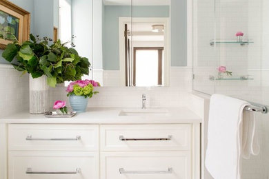 Example of a mid-sized transitional master white tile and subway tile mosaic tile floor and white floor alcove shower design in New York with shaker cabinets, white cabinets, blue walls, an undermount sink, a hinged shower door and quartz countertops
