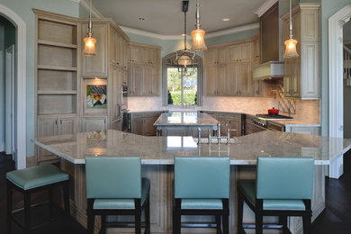 Inspiration for a large transitional u-shaped open plan kitchen in Houston with a farmhouse sink, raised-panel cabinets, light wood cabinets, marble benchtops, grey splashback, mosaic tile splashback, stainless steel appliances, dark hardwood floors and multiple islands.