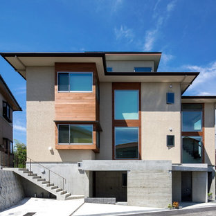 他の地域のアジアンスタイルのおしゃれな三階建ての家 (漆喰サイディング、ベージュの外壁、片流れ屋根、戸建、金属屋根) の写真