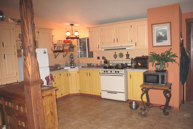 ロサンゼルスにある低価格のラスティックスタイルのおしゃれなキッチン (ドロップインシンク、レイズドパネル扉のキャビネット、黄色いキャビネット、ピンクのキッチンパネル、白い調理設備) の写真