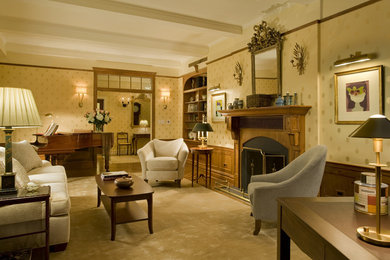 Example of a classic formal medium tone wood floor living room design in New York with white walls, a standard fireplace and a wood fireplace surround