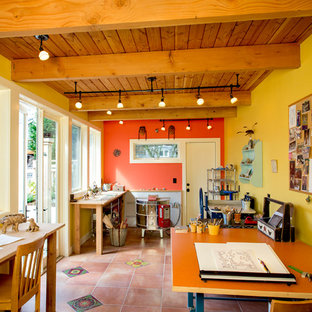 Photo of a home studio in Seattle with yellow walls, terra-cotta floors and a freestanding desk.