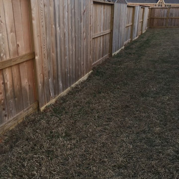 Install boards at the bottom of cedar fence to help keep owners dog in the yard.