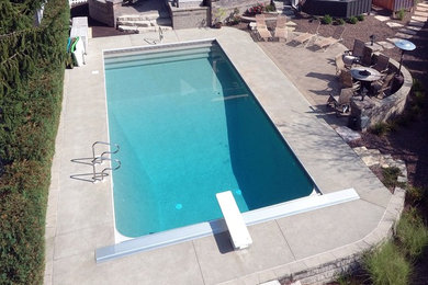 Foto de piscina clásica grande rectangular en patio trasero