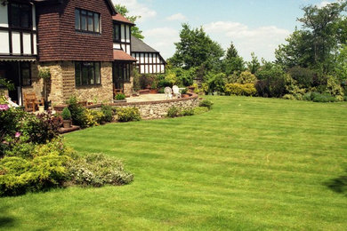Photo of a mid-sized traditional partial sun backyard landscaping in London for summer.