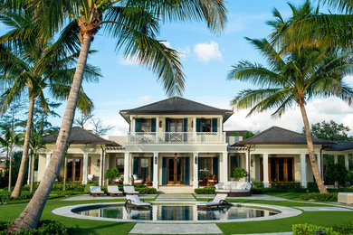 This is an example of an expansive tropical two-storey stucco beige exterior in Miami.
