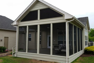 This is an example of a huge traditional screened-in side porch design in Chicago with decking.