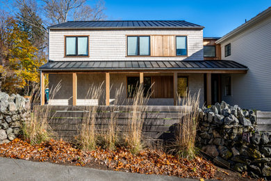 Example of a large transitional two-story wood and shingle exterior home design in Boston with a metal roof and a black roof
