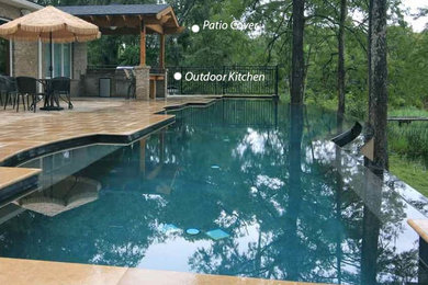 Pool house - mid-sized modern backyard stone and custom-shaped infinity pool house idea in Houston
