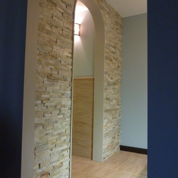 Elegant arched stone wall separating vanity area from toilet/shower area