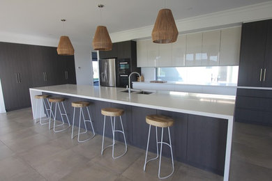 Expansive contemporary l-shaped open plan kitchen in Other with an undermount sink, flat-panel cabinets, grey cabinets, quartz benchtops, glass sheet splashback, coloured appliances, ceramic floors and with island.