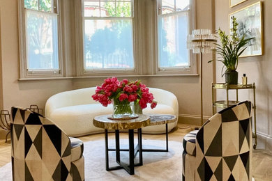 Medium sized contemporary formal open plan living room in London with light hardwood flooring, a standard fireplace, no tv and feature lighting.