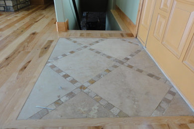 Elegant light wood floor entryway photo in Denver with a light wood front door