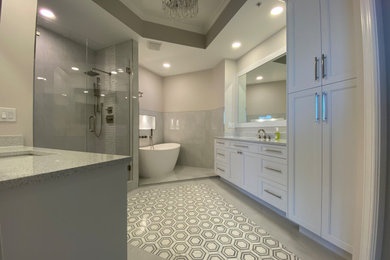 Large trendy master gray tile and porcelain tile porcelain tile, gray floor and double-sink bathroom photo in Miami with shaker cabinets, white cabinets, a two-piece toilet, white walls, an undermount sink, quartzite countertops, a hinged shower door, white countertops and a built-in vanity