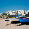 Beached Boats with City in the Background Canvas Wall Art