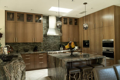 Enclosed kitchen - large contemporary u-shaped porcelain tile and white floor enclosed kitchen idea in Las Vegas with an undermount sink, flat-panel cabinets, light wood cabinets, granite countertops, green backsplash, glass tile backsplash, paneled appliances, an island and green countertops