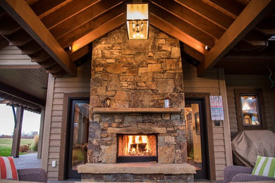 Mid-sized mountain style backyard patio photo in Other with a fire pit and a roof extension