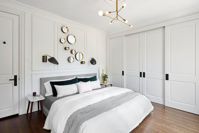 Photo of a transitional bedroom in Toronto with white walls, dark hardwood floors and brown floor.