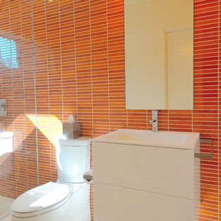 Idee per una stanza da bagno con doccia moderna di medie dimensioni con ante lisce, ante bianche, doccia alcova, WC monopezzo, piastrelle arancioni, piastrelle a mosaico, pareti multicolore, pavimento in gres porcellanato, lavabo integrato, top in quarzo composito, pavimento bianco e doccia aperta