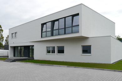 Small and white contemporary two floor render house exterior in Dusseldorf with a flat roof.