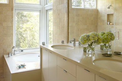 Photo of a modern bathroom in San Francisco with an undermount sink, solid surface benchtops, a curbless shower and an undermount tub.