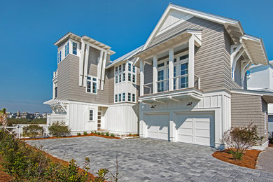 Large beach style beige three-story wood exterior home photo in Miami with a shingle roof