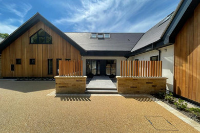 Inspiration for a contemporary front house exterior in Cheshire with wood cladding.