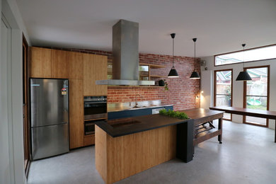 Mid-sized contemporary galley eat-in kitchen in Melbourne with a double-bowl sink, stainless steel benchtops, stainless steel appliances, concrete floors and with island.