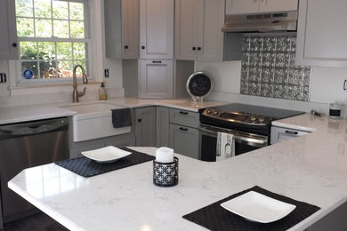 Inspiration for a small modern l-shaped kitchen remodel in Philadelphia with a farmhouse sink, recessed-panel cabinets, white cabinets, stainless steel appliances and a peninsula