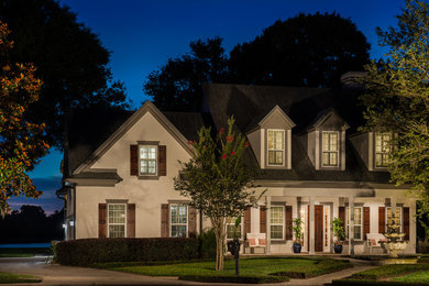 Example of a large mountain style beige two-story stucco exterior home design in Orlando with a mixed material roof
