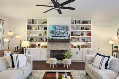 Example of a mid-sized transitional open concept medium tone wood floor, brown floor and shiplap wall living room design in Nashville with white walls, a standard fireplace, a stone fireplace and a wall-mounted tv
