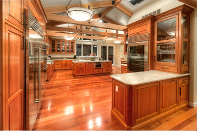Example of a large classic l-shaped medium tone wood floor open concept kitchen design in San Francisco with raised-panel cabinets, medium tone wood cabinets, granite countertops, stainless steel appliances, an island, multicolored backsplash and subway tile backsplash