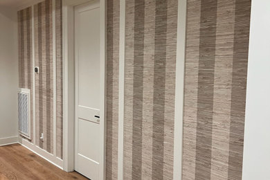 Example of a transitional medium tone wood floor, brown floor and wallpaper hallway design in Las Vegas with white walls