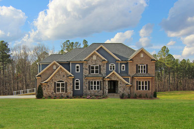 Photo of an expansive three-storey blue exterior in Raleigh with mixed siding.