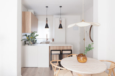 Diseño de cocinas en U beige y blanco contemporáneo de tamaño medio abierto con fregadero de un seno, armarios con paneles lisos, puertas de armario beige, encimera de cuarzo compacto, salpicadero blanco, salpicadero de azulejos de cerámica, electrodomésticos con paneles, suelo laminado, península, suelo marrón y encimeras blancas
