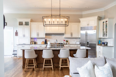 Eat-in kitchen - mid-sized l-shaped dark wood floor and brown floor eat-in kitchen idea in St Louis with an undermount sink, louvered cabinets, white cabinets, granite countertops, white backsplash, subway tile backsplash, stainless steel appliances, an island and gray countertops