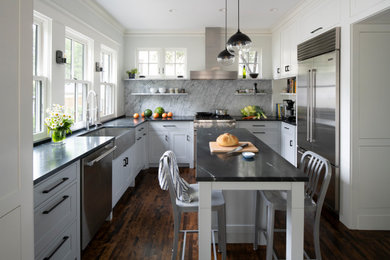 Example of a transitional u-shaped dark wood floor kitchen design in Minneapolis with blue cabinets, stainless steel appliances, an island and black countertops