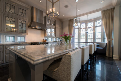 Photo of a large traditional l-shaped eat-in kitchen in Chicago with marble benchtops, white splashback, with island, a farmhouse sink, shaker cabinets, grey cabinets, subway tile splashback, stainless steel appliances and marble floors.